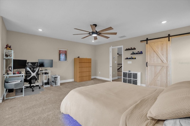 carpeted bedroom featuring ceiling fan and a barn door