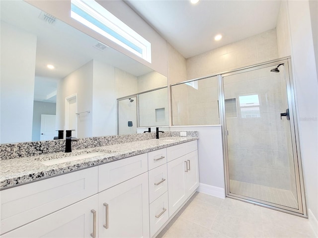 bathroom with vanity, tile patterned floors, and a shower with door