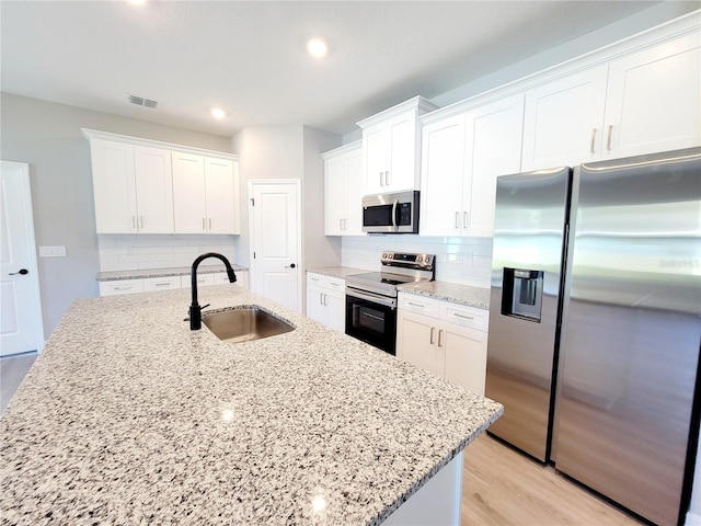 kitchen featuring stainless steel appliances, sink, and white cabinets