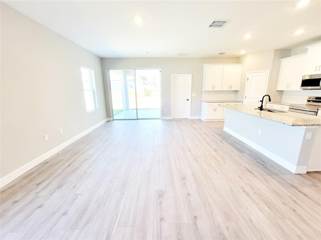 kitchen featuring stainless steel appliances, light wood-type flooring, and white cabinets