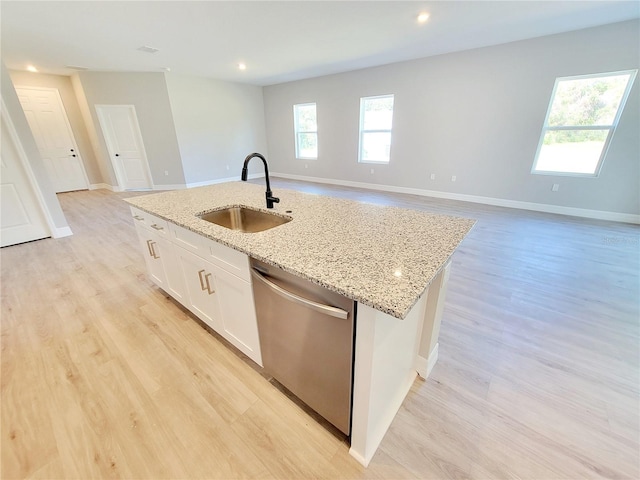 kitchen featuring an island with sink, white cabinetry, light wood-type flooring, dishwasher, and sink