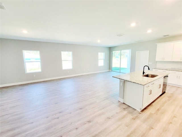 kitchen featuring a kitchen island with sink, dishwasher, a healthy amount of sunlight, and sink