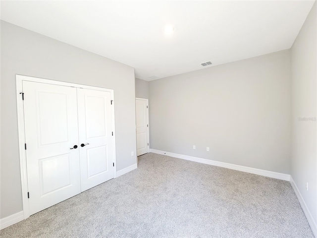 unfurnished bedroom with a closet and light carpet