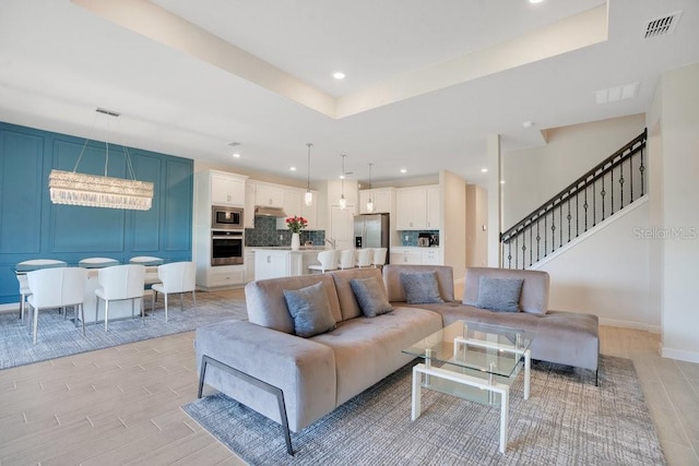 living room featuring a notable chandelier and light hardwood / wood-style flooring