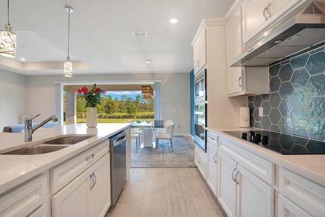 kitchen with pendant lighting, appliances with stainless steel finishes, sink, and white cabinetry