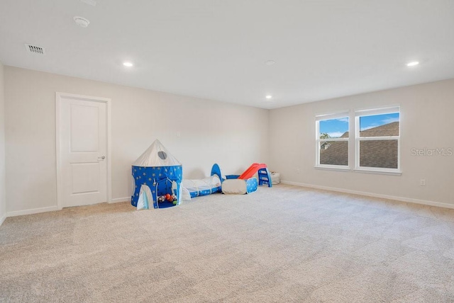 recreation room with light colored carpet