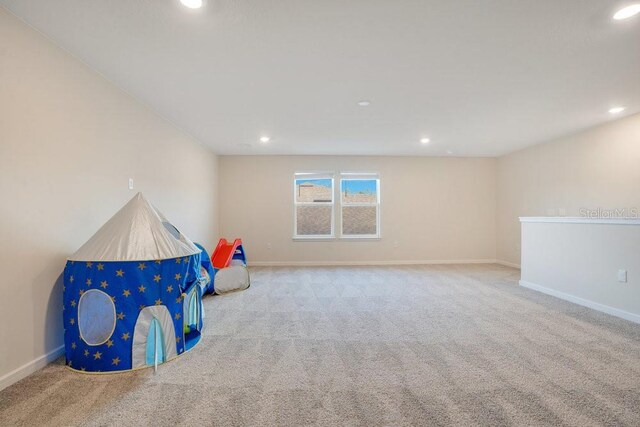 rec room featuring light colored carpet