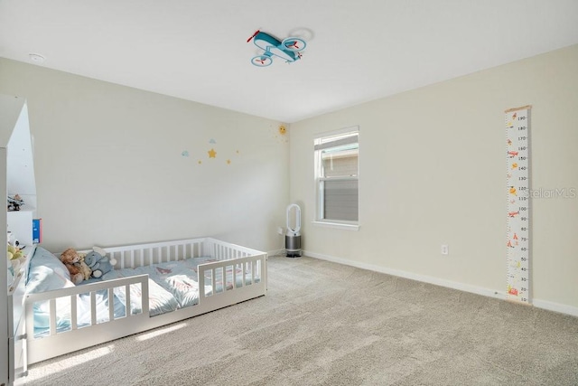 carpeted bedroom featuring a nursery area