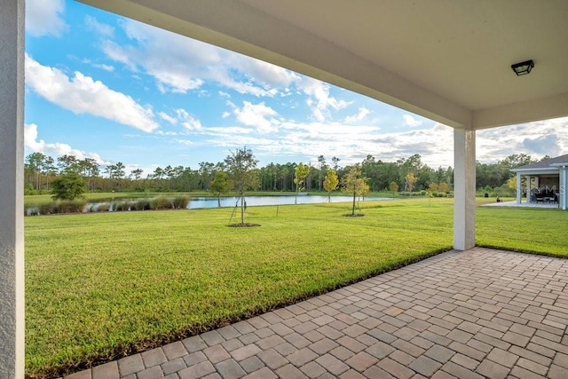 view of yard with a water view and a patio