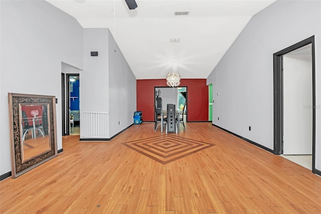 interior space featuring lofted ceiling, ceiling fan with notable chandelier, and hardwood / wood-style floors