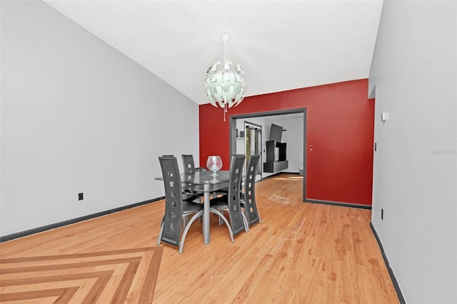 dining space featuring hardwood / wood-style flooring and an inviting chandelier