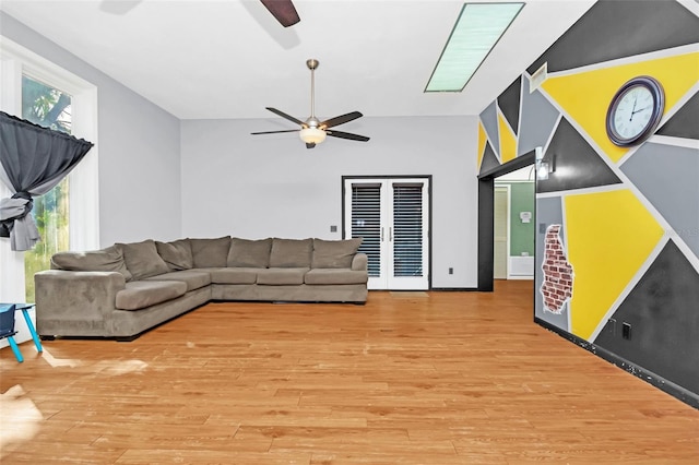 living room with light hardwood / wood-style floors, ceiling fan, and a wealth of natural light