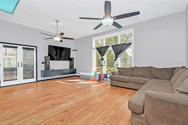 living room featuring ceiling fan and light hardwood / wood-style flooring