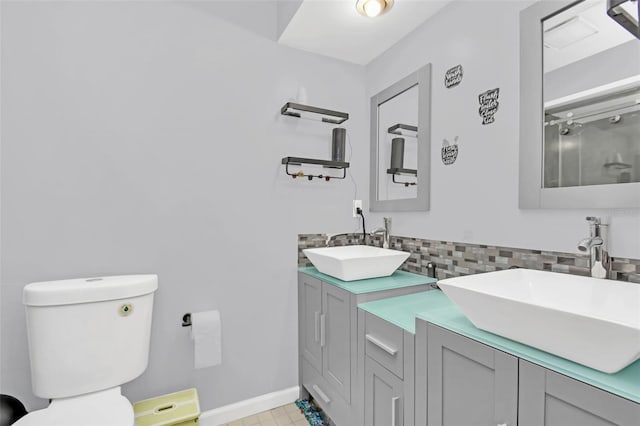 bathroom featuring vanity, decorative backsplash, and toilet