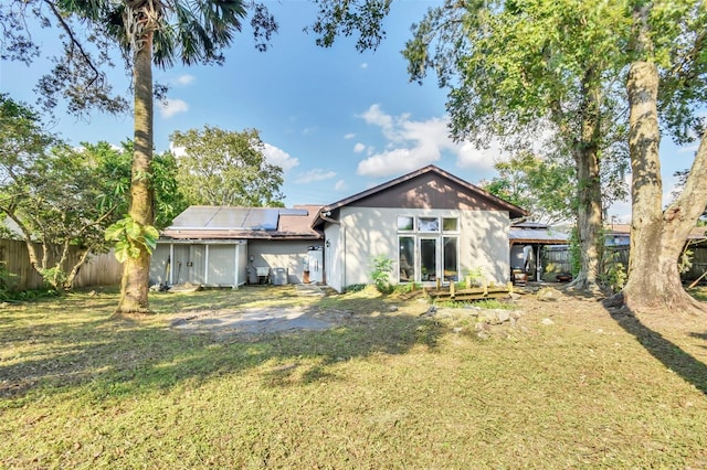 rear view of property featuring a lawn