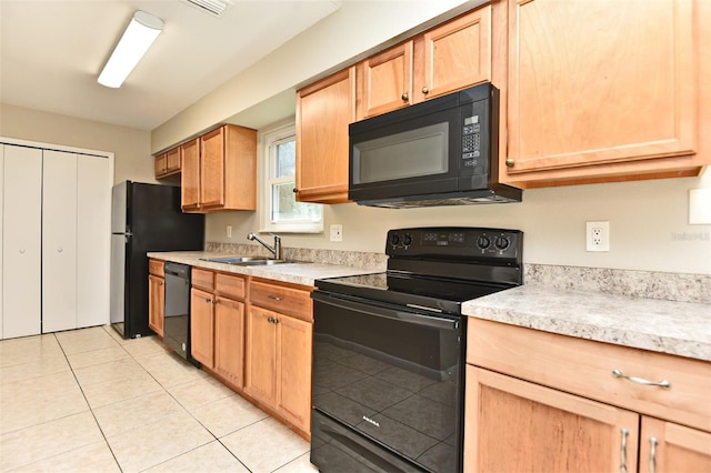 kitchen with light tile patterned flooring, sink, and black appliances