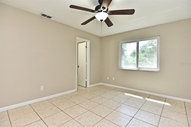 spare room with ceiling fan and light tile patterned floors