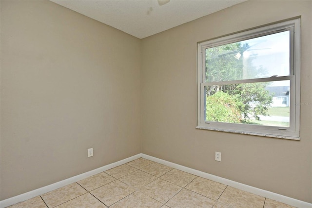 tiled spare room featuring a textured ceiling