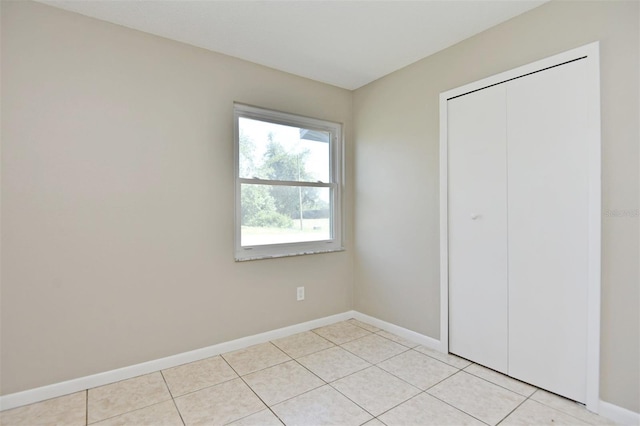 unfurnished bedroom with a closet and light tile patterned floors