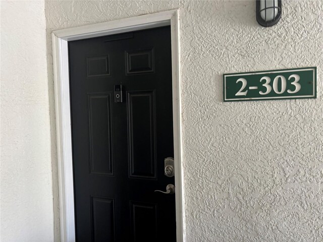 doorway to property featuring stucco siding