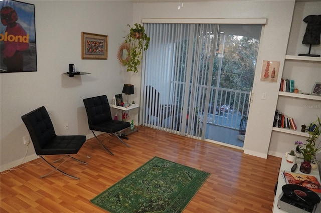 sitting room with hardwood / wood-style flooring and built in features