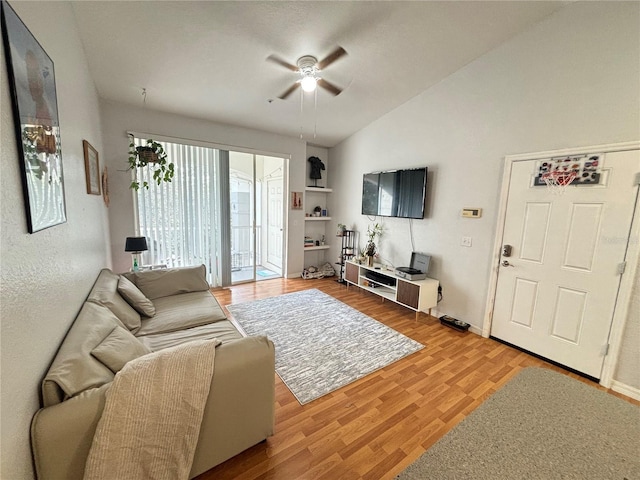 living room with ceiling fan, lofted ceiling, built in features, and hardwood / wood-style flooring