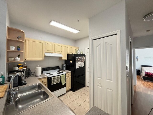 kitchen with light tile patterned floors, black refrigerator, tasteful backsplash, white electric range oven, and sink