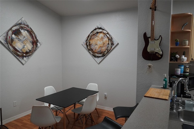 dining area with wood-type flooring and sink