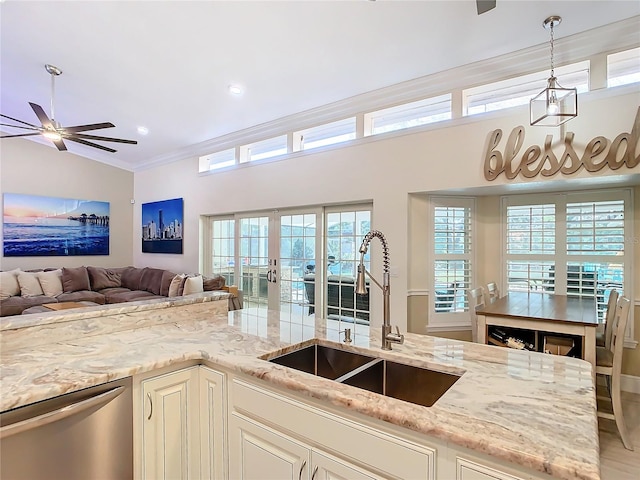 kitchen with pendant lighting, sink, light stone counters, and dishwasher