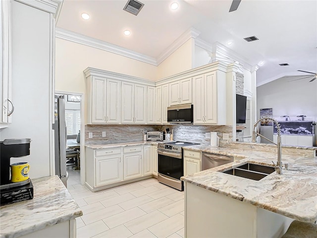 kitchen featuring light stone countertops, kitchen peninsula, ceiling fan, stainless steel appliances, and vaulted ceiling