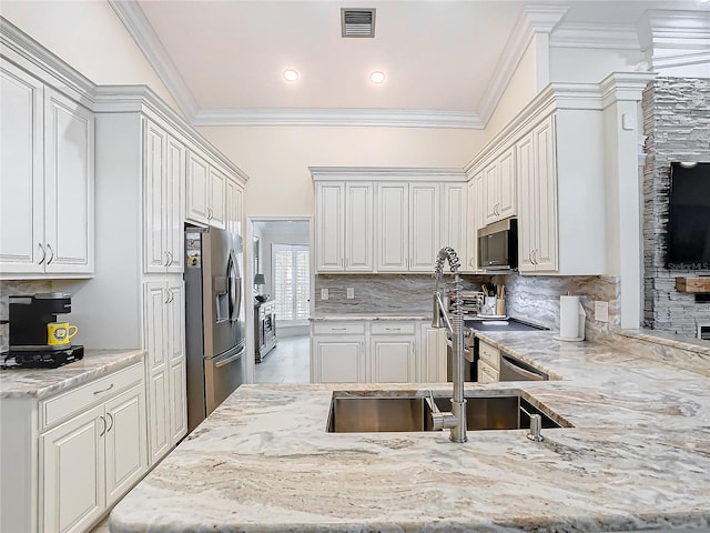 kitchen with light stone counters, stainless steel appliances, and white cabinets