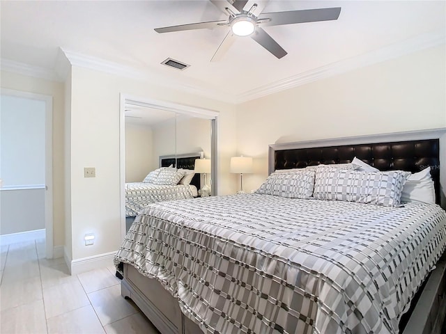 bedroom featuring a closet, light tile patterned floors, crown molding, and ceiling fan