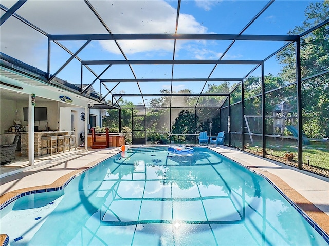 view of swimming pool with a hot tub, a patio area, and glass enclosure