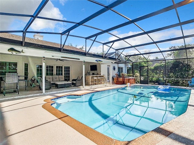 view of pool with ceiling fan, a lanai, a patio area, and outdoor lounge area