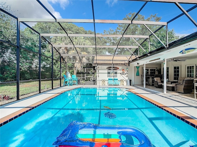 view of pool with an outdoor living space, a patio, glass enclosure, and ceiling fan