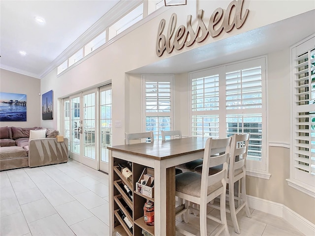 dining space featuring french doors, ornamental molding, and light tile patterned floors