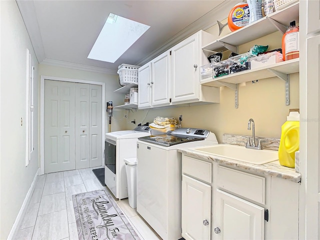 washroom featuring a skylight, sink, separate washer and dryer, ornamental molding, and cabinets