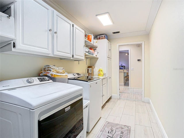 laundry room featuring cabinets and washer and dryer