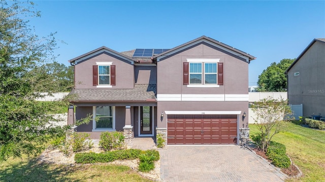 view of front facade featuring solar panels, a garage, and a front lawn