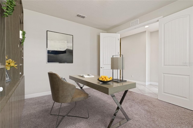 carpeted home office featuring a textured ceiling