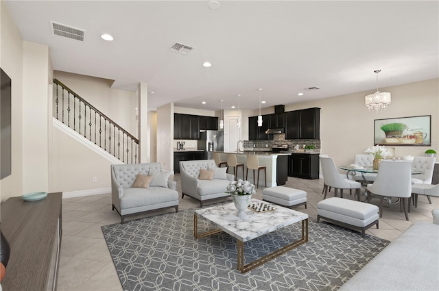 living room featuring a chandelier, sink, and light tile patterned floors