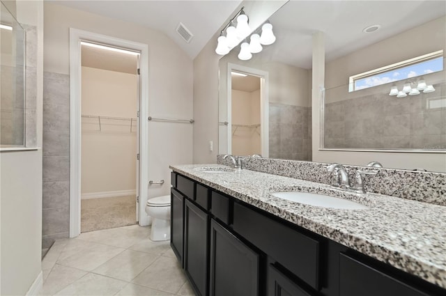 bathroom featuring vanity, lofted ceiling, toilet, and tile patterned flooring