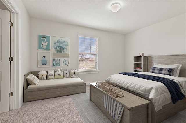 bedroom with a textured ceiling and light colored carpet