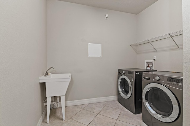 washroom featuring washing machine and dryer and light tile patterned floors