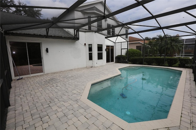 view of pool with a patio and glass enclosure