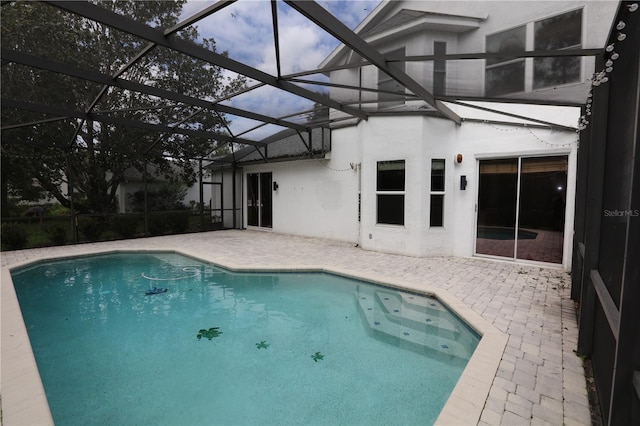 view of swimming pool with a patio area and glass enclosure