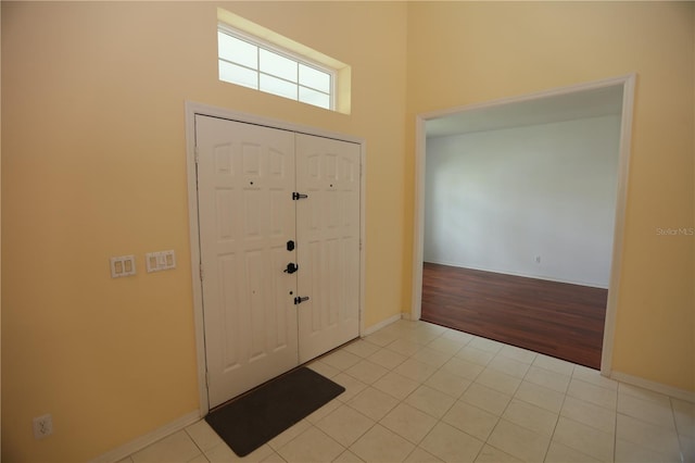 foyer entrance featuring a high ceiling and light hardwood / wood-style floors