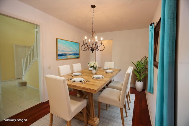 dining space with hardwood / wood-style floors and a chandelier