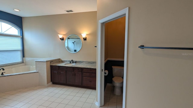 bathroom featuring vanity, a relaxing tiled tub, toilet, and tile patterned flooring