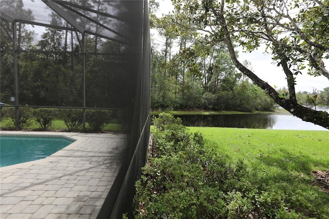 view of pool featuring a patio area, a lanai, a lawn, and a water view